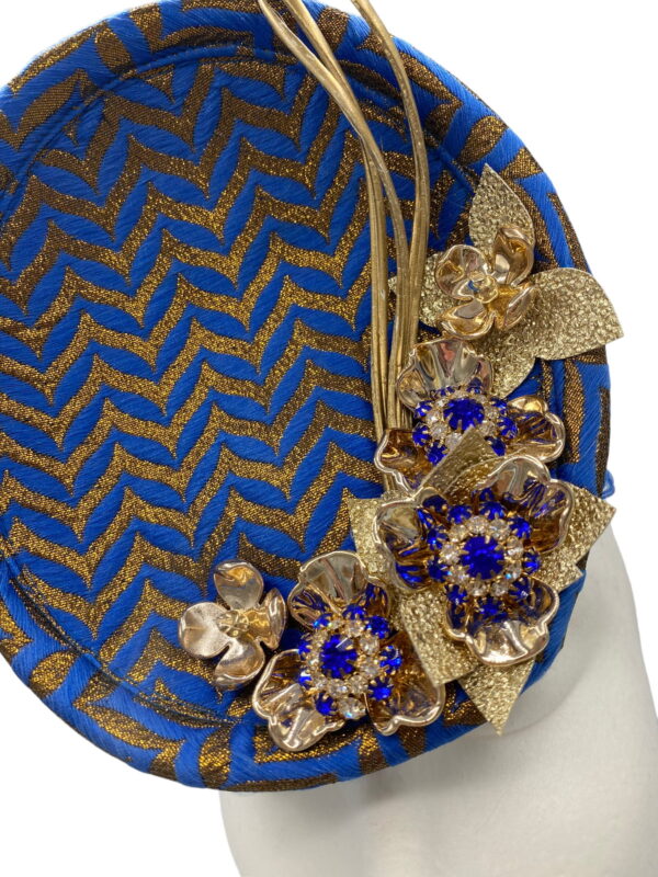 Blue and gold chevron detail percher with gold flower and quill detail.